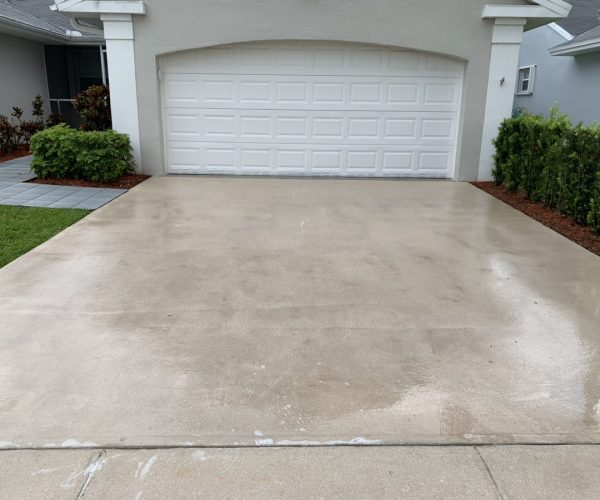 concrete driveway after cleaning with white garage door